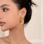 Orecchini a cerchio intrecciati con conchiglia placcati oro - immagine 3