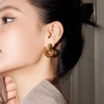 Orecchini a cerchio intrecciati con conchiglia placcati oro - immagine 2