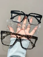 Occhiali geometrici eleganti con lenti trasparenti